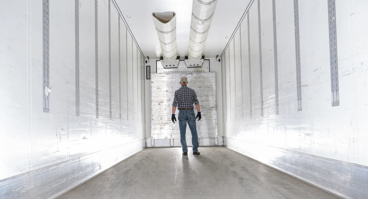 Worker Standing Inside a Refrigerated Truck Trailer