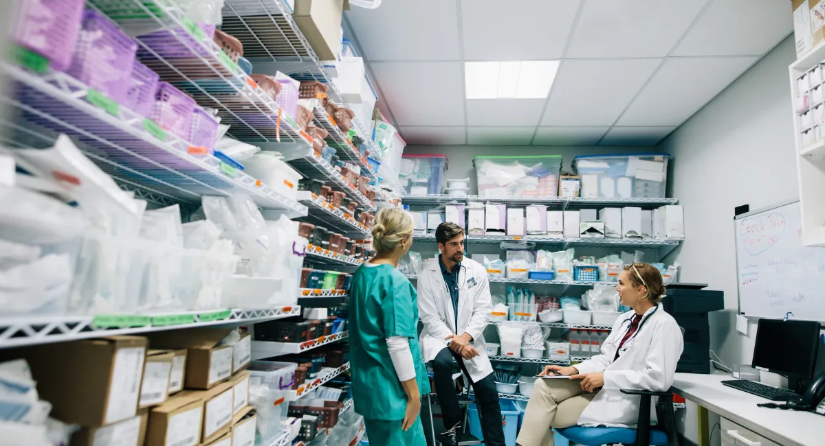 Medical staff discussing in hospital supply room.