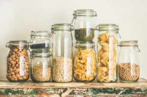 Glass jars with dried food stored in pantry.