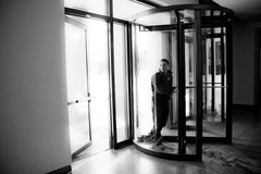 A person entering a lobby through rotating doors.