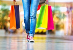 A person carrying multicolored shopping bags.