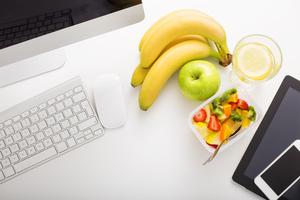 A collection of fresh fruit on a white desk.