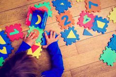 A child playing with foam squares at daycare.
