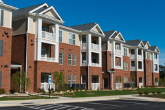 A brown and white apartment complex on a sunny day.