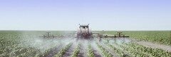 A field being sprayed with pesticides.