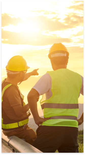 Two people in construction gear looking out at the sky.